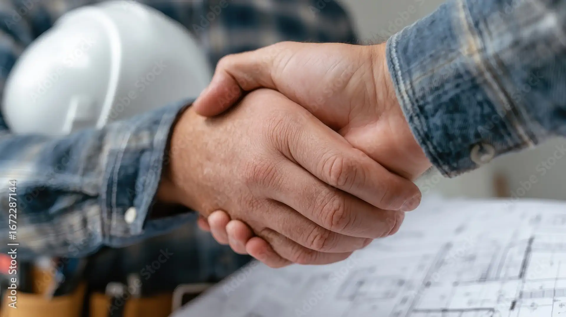 contractor-handshake-over-blueprints-construction-agreement